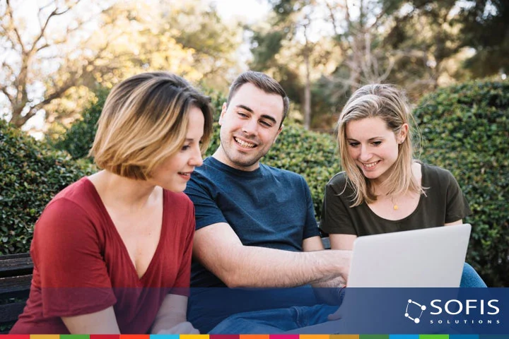 Hombre y mujeres viendo la pantalla de una computadora